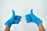 person wearing blue gloves holding hands