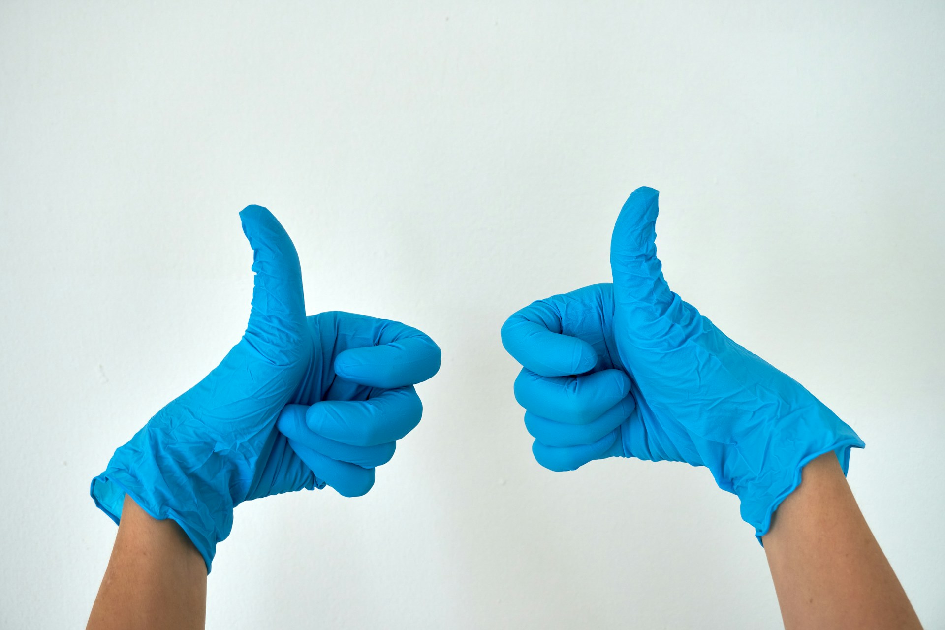 person wearing blue gloves holding hands