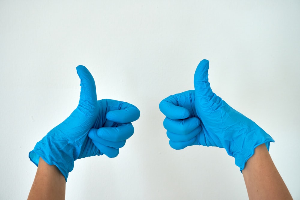 person wearing blue gloves holding hands