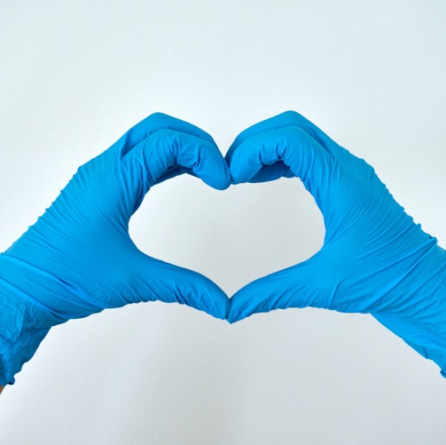 A medical professional making a heart sign with his hands