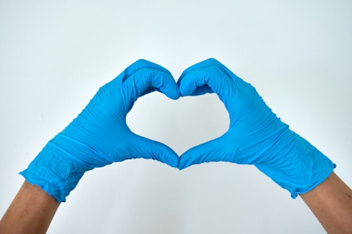 A medical professional making a heart sign with his hands