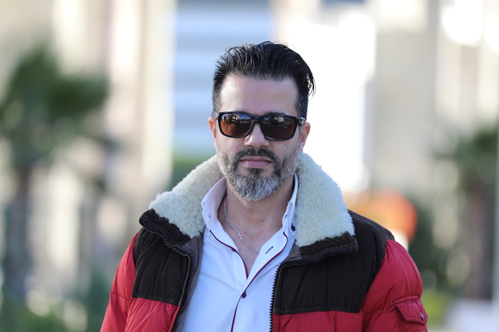 man in red and black jacket wearing black sunglasses