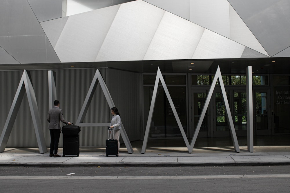 people walking on sidewalk near gray building during daytime