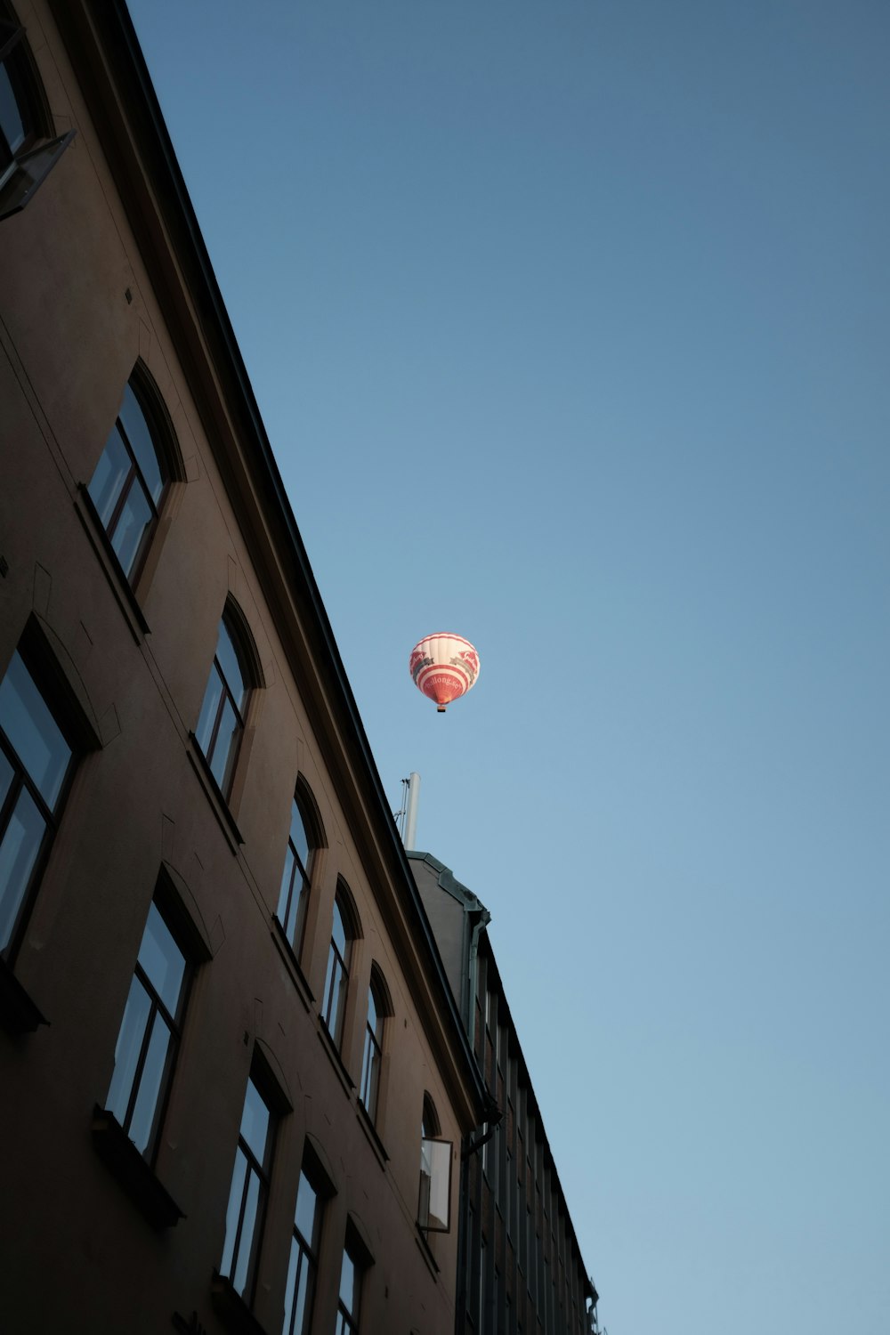 balão de ar quente rosa e branco no ar durante o dia