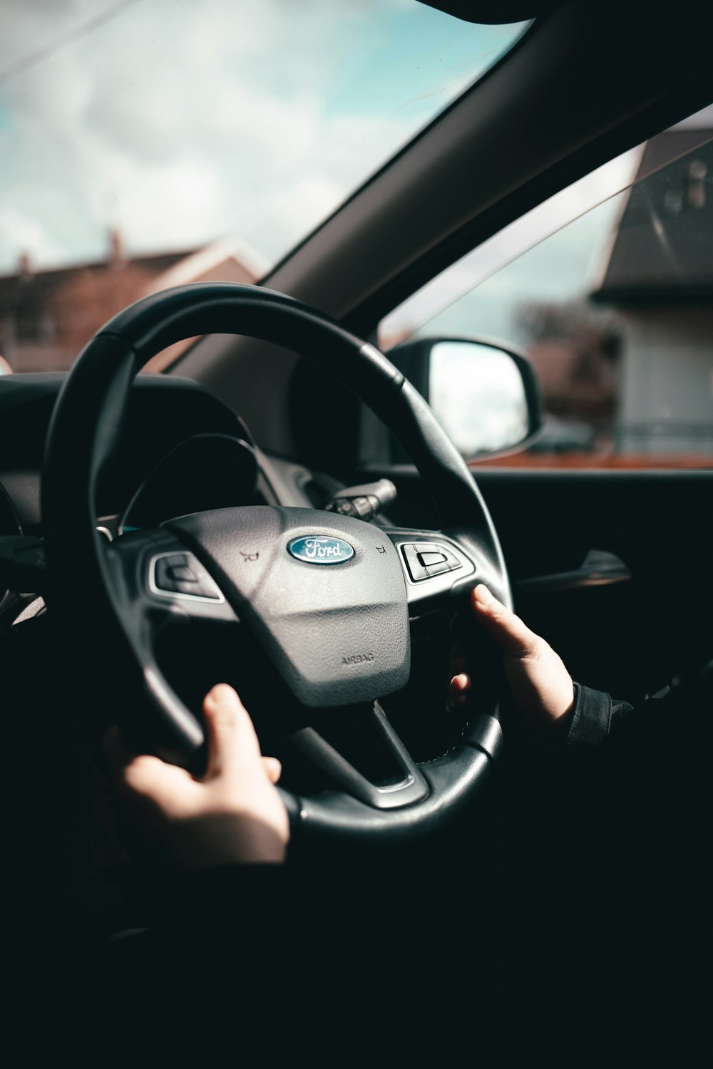 person holding black bmw steering wheel