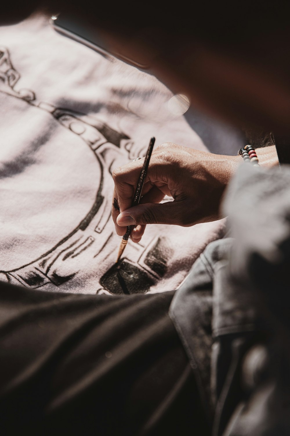 person in blue denim jacket holding pen