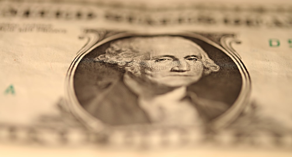 us dollar bill on brown wooden table