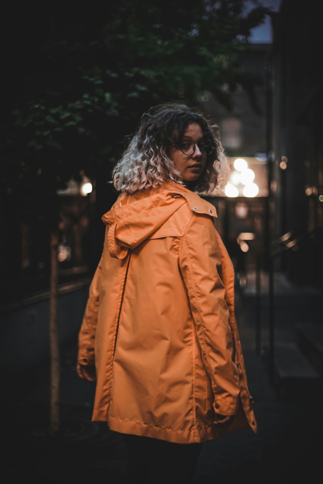 woman in brown coat standing during night time