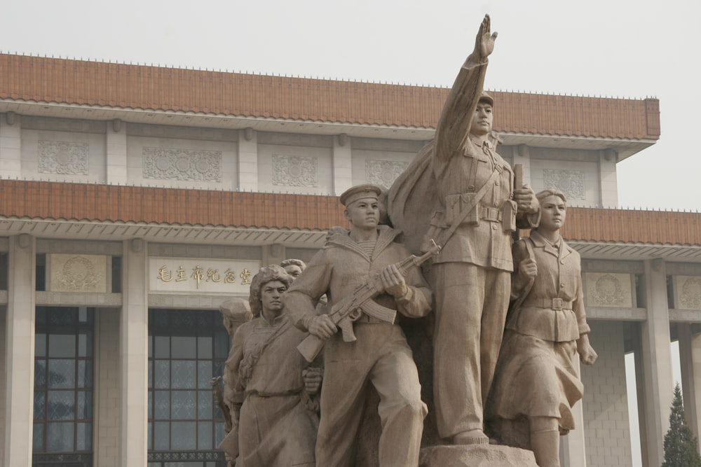 man in coat statue near building during daytime