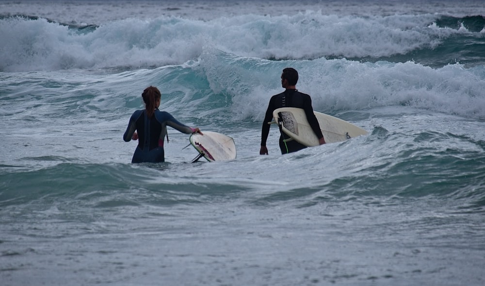 man in black wet suit surfing on sea waves during daytime