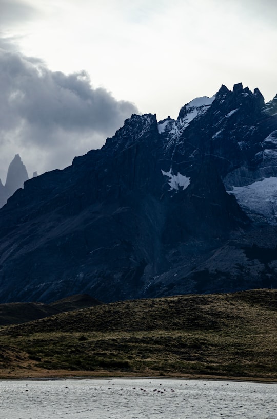 brown and white mountain under white clouds during daytime in Torres del Paine Chile