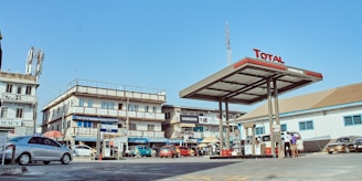 A bright, modern petrol pump station bustling with vehicles near Lahore under a clear blue sky.