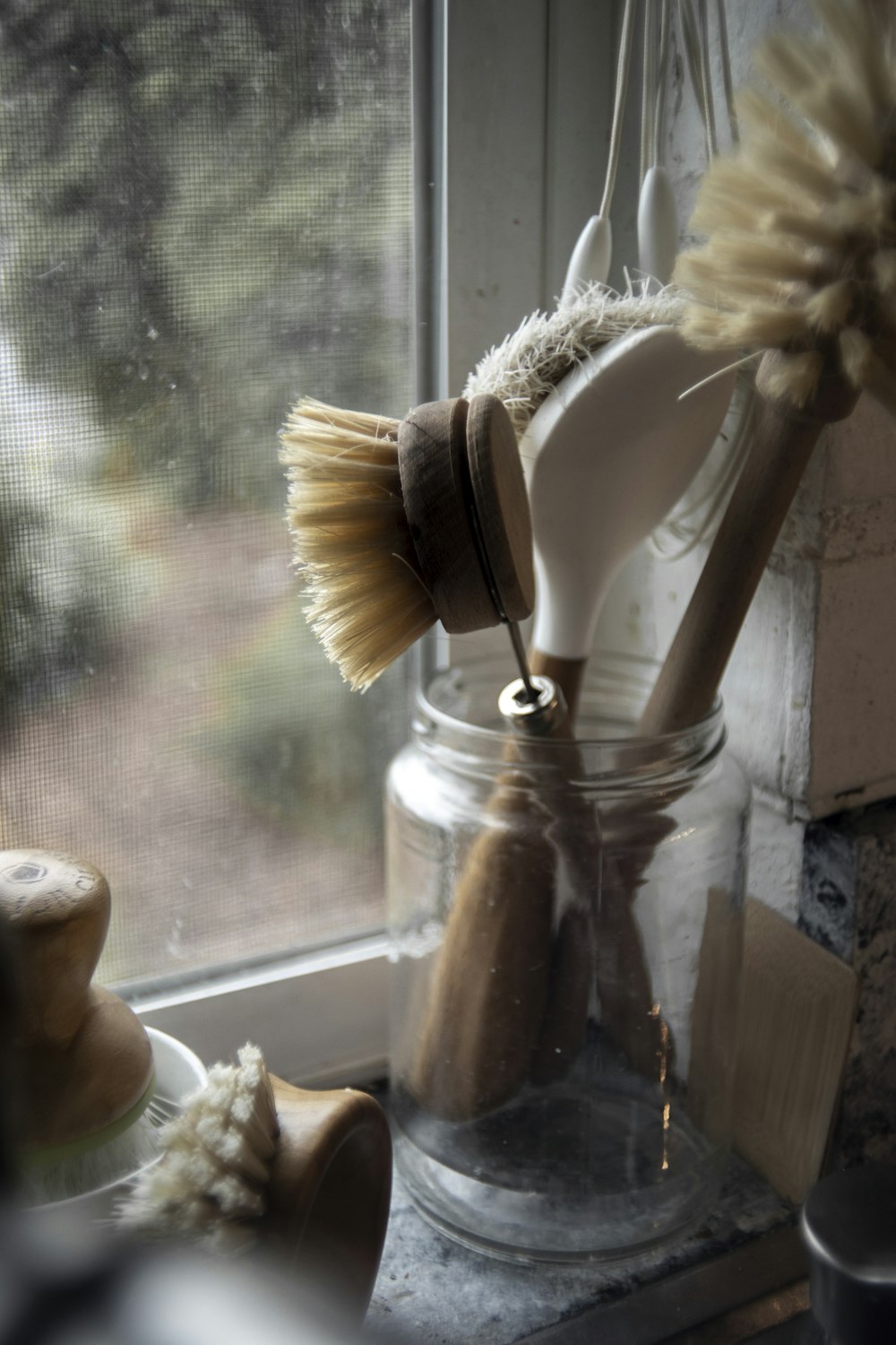 brown wooden brush on clear glass jar