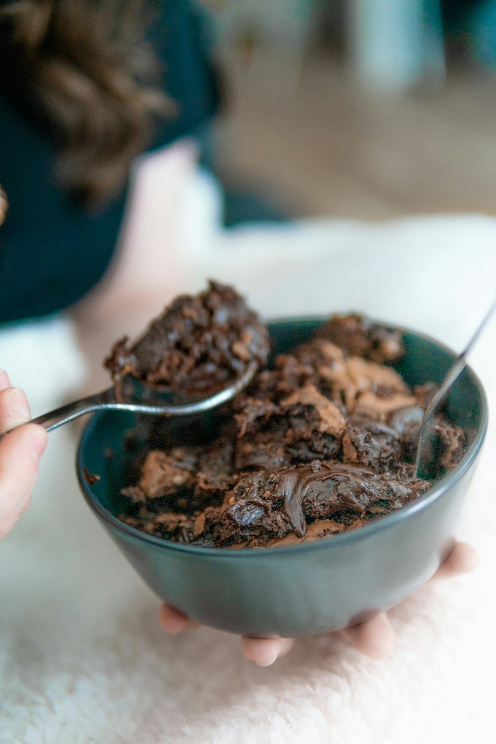 Persona sosteniendo una cuchara de acero inoxidable con helado de chocolate