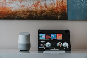 black ipad beside white portable speaker