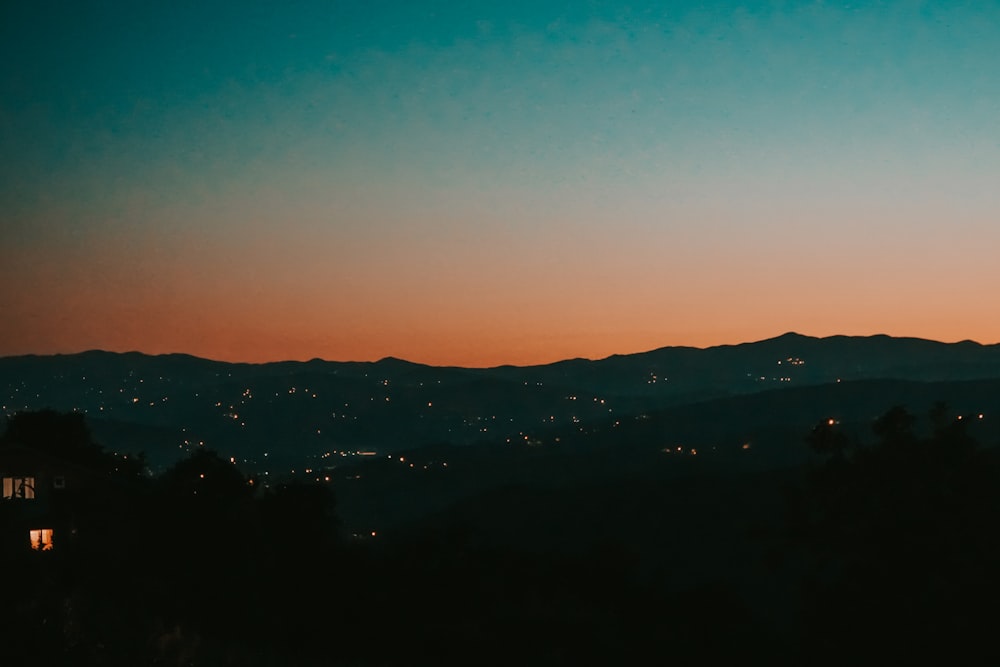 silhouette of mountains during night time