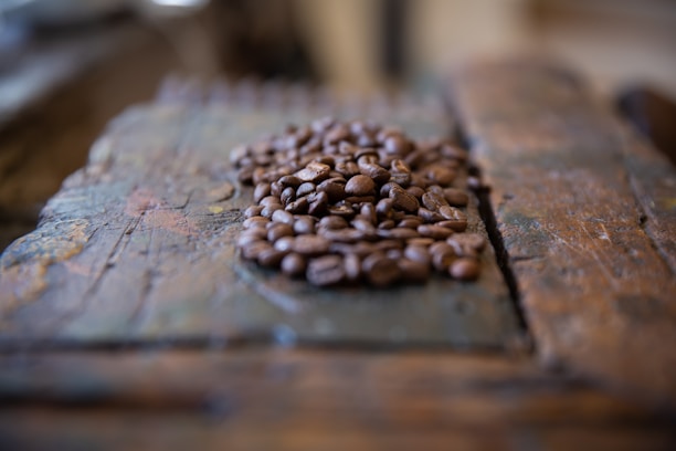 Close-up of aromatic coffee beans with a rustic wooden backdrop emphasizing natural origin.