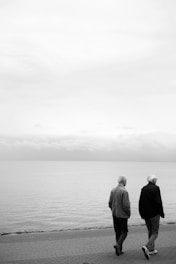 man and woman standing on seashore