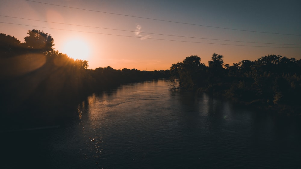 Plan d’eau près des arbres au coucher du soleil