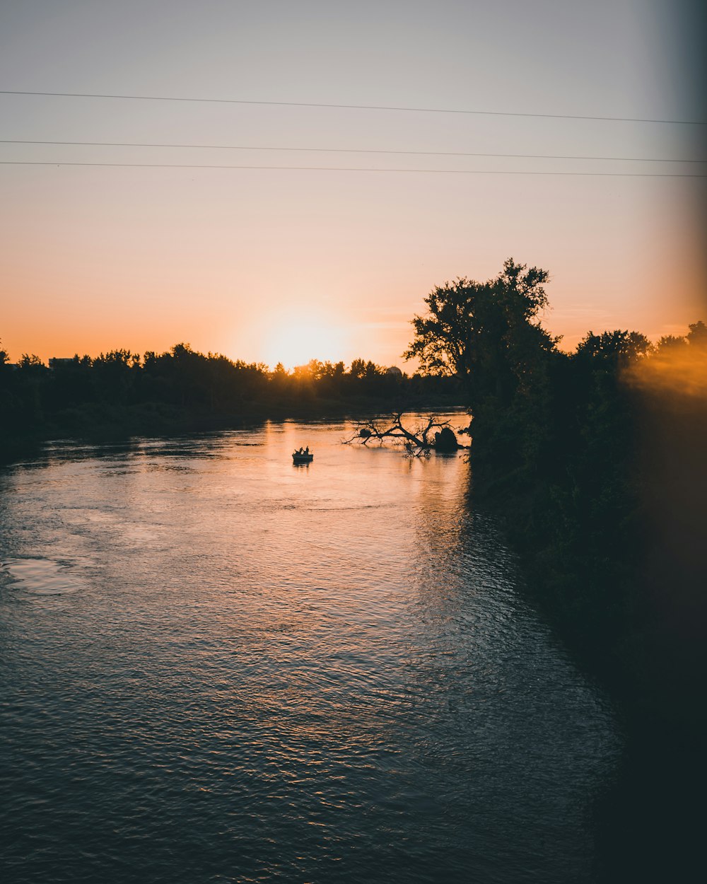 silhouette of people riding horses on lake during sunset