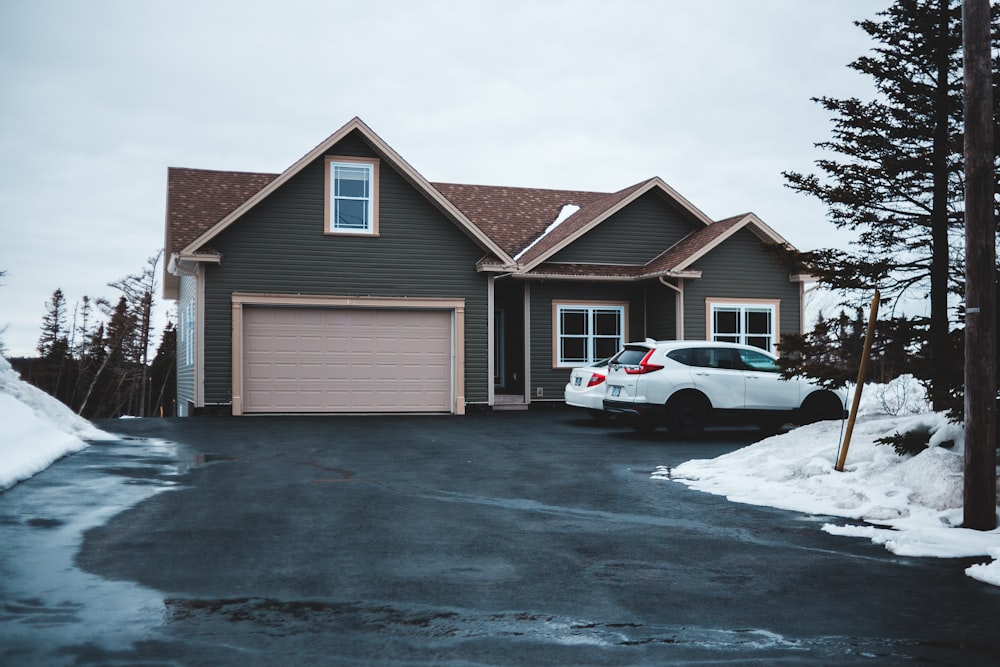 white car parked in front of brown wooden house during daytime