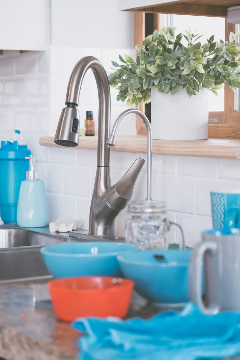 stainless steel faucet near blue plastic bowl