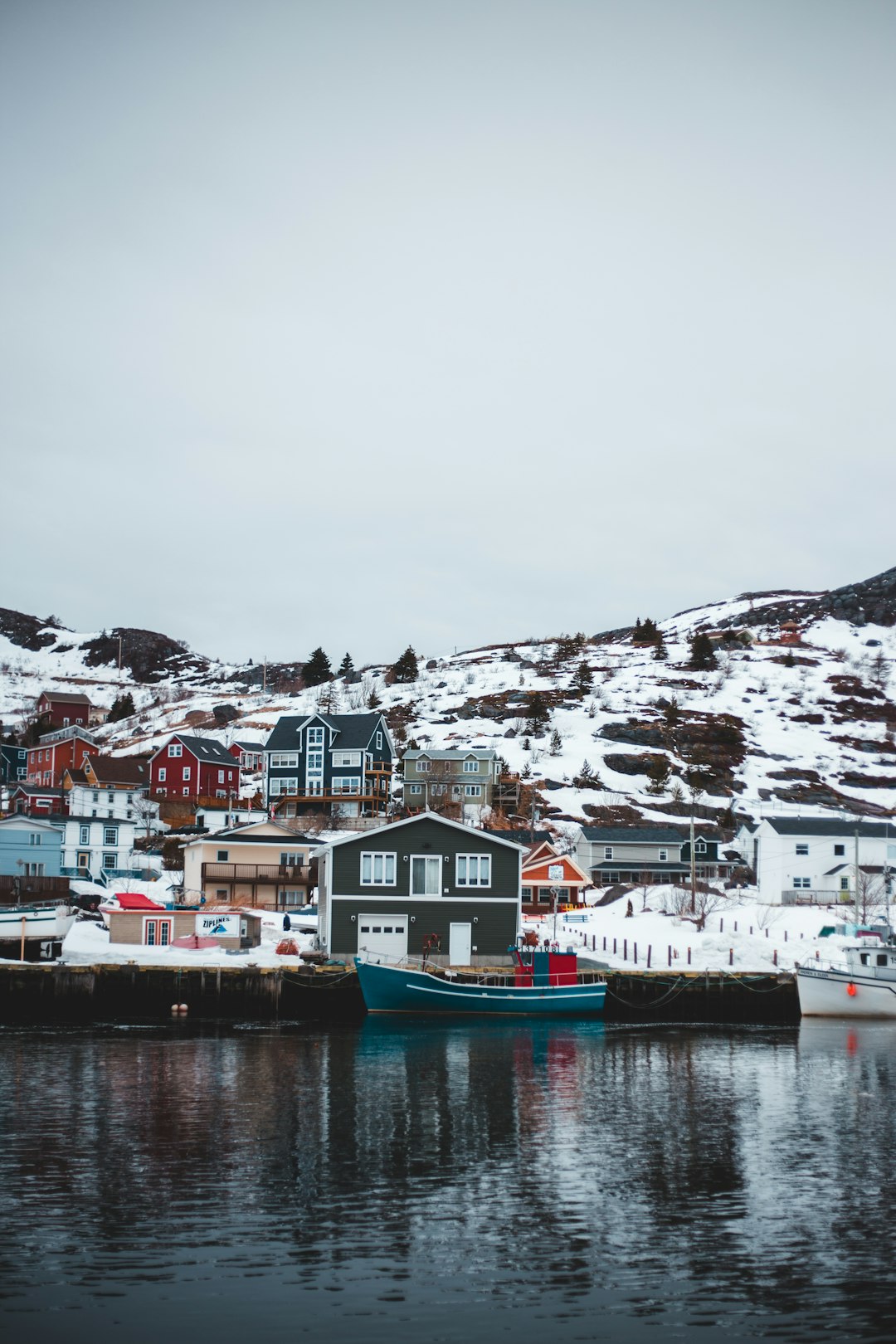 blue and white boat on body of water near white and brown buildings during daytime