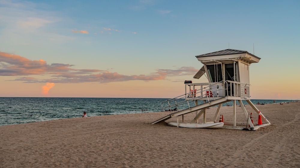 white wooden lifeguard house on beach during daytime