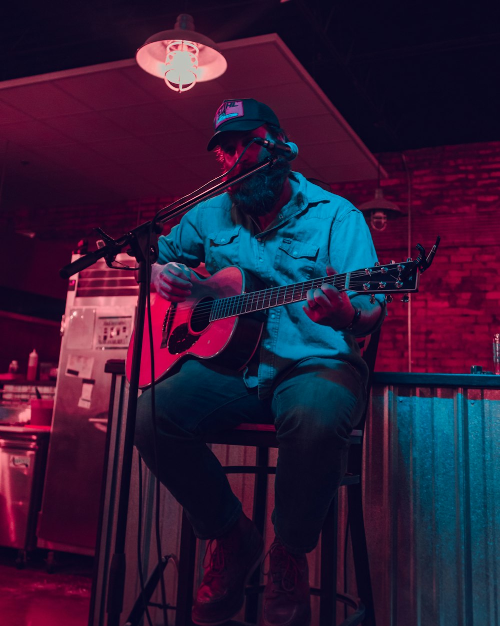 man in red hat playing guitar