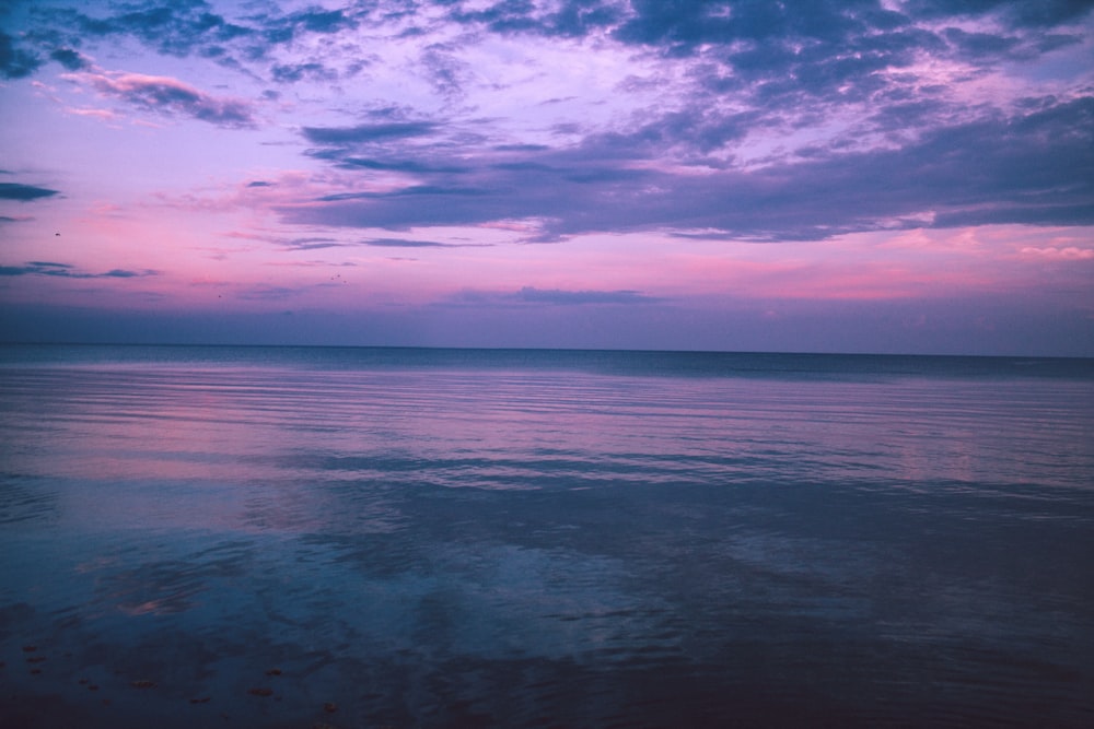 body of water under cloudy sky during daytime