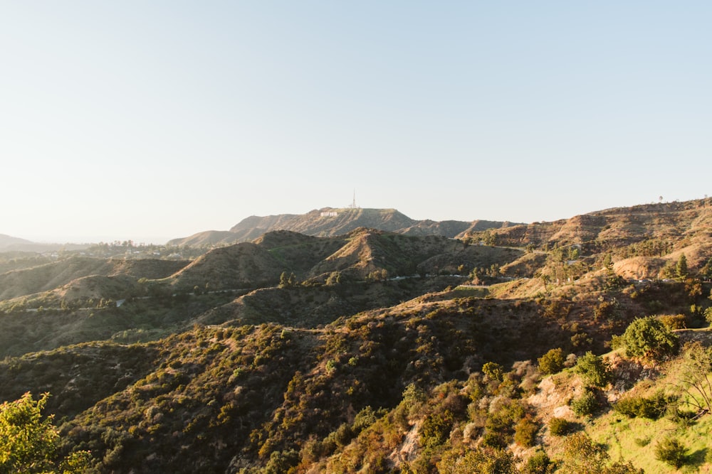 a scenic view of a mountain with trees and hills in the background