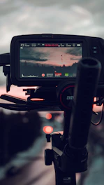 black dslr camera taking photo of sunset
