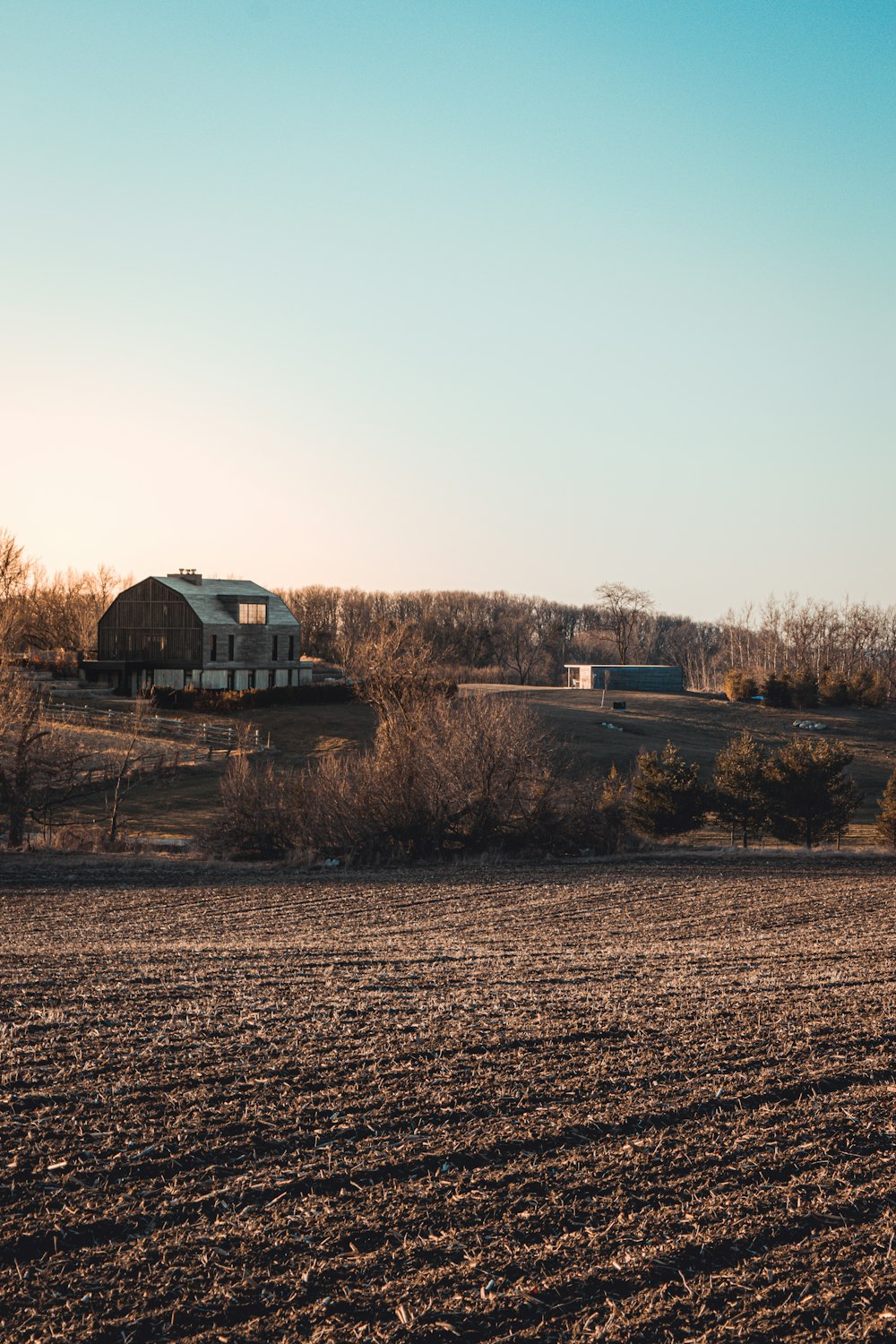 casa branca e preta no campo marrom durante o dia