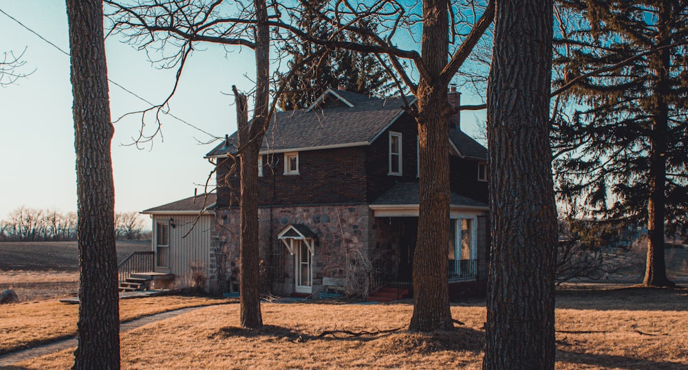 a house in the middle of a field surrounded by trees