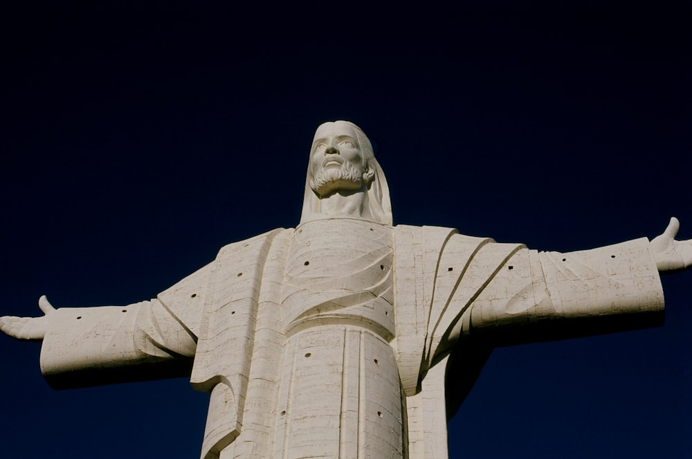 Statue en béton blanc sous le ciel bleu pendant la journée