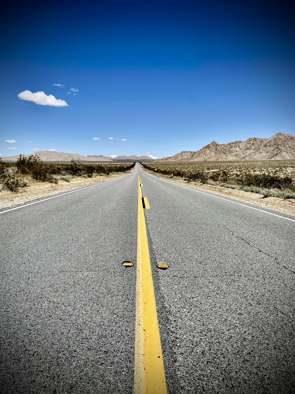 gray concrete road under blue sky during daytime