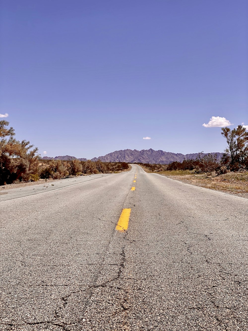 gray asphalt road under blue sky during daytime