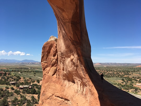 brown rock formation under blue sky during daytime in Wilson Arch United States