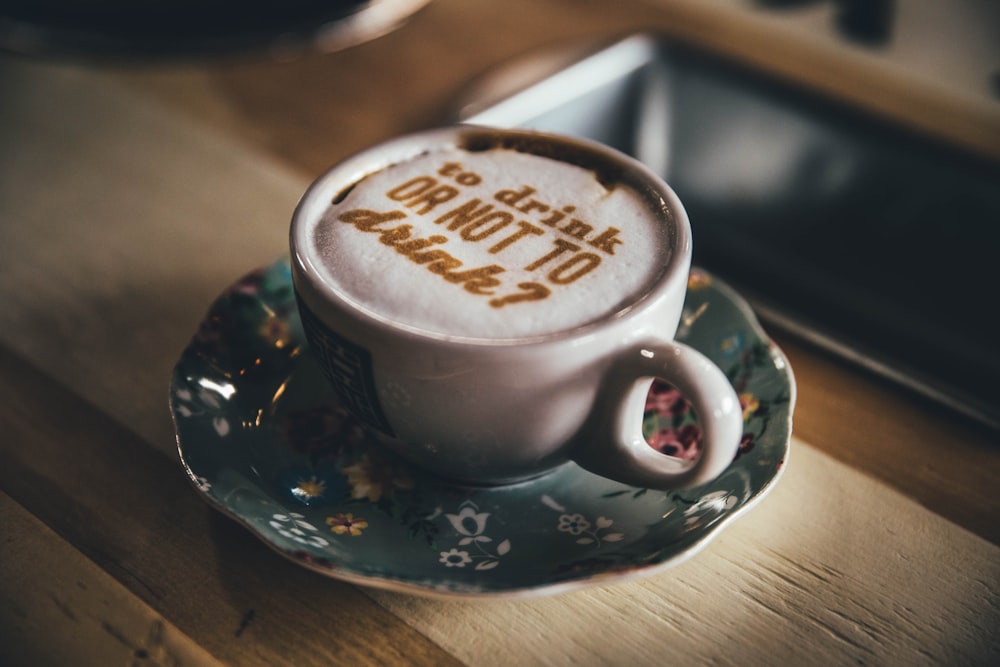 white ceramic cup with saucer on brown wooden table