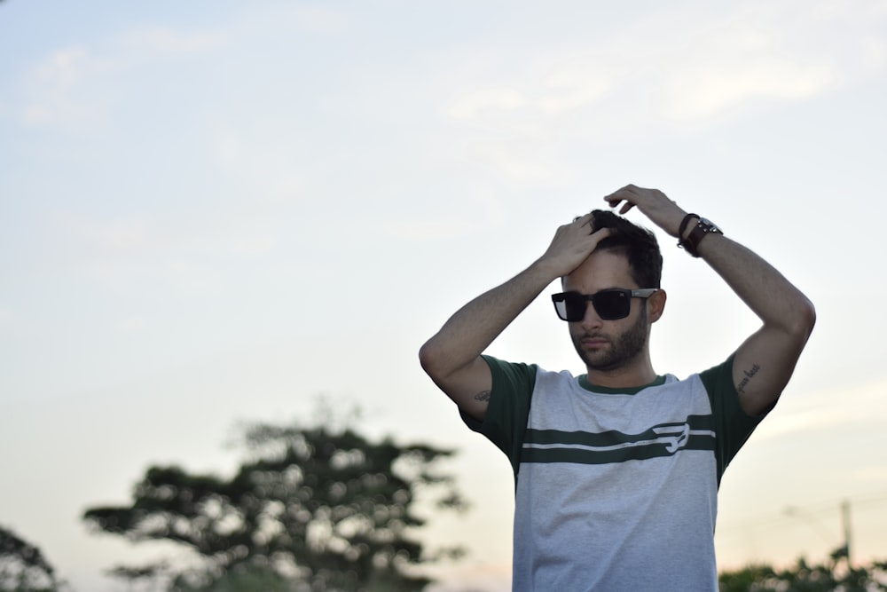 man in gray and green tank top wearing black sunglasses