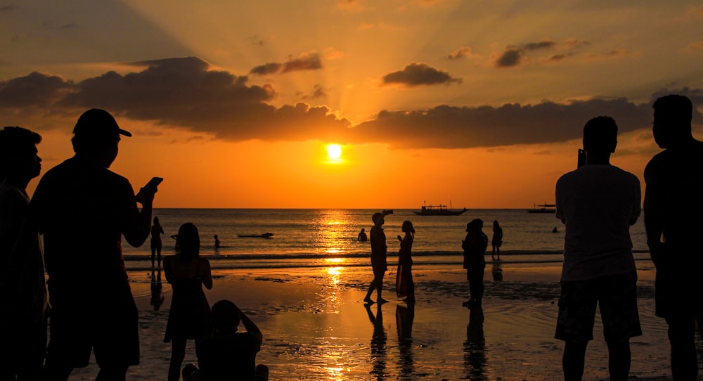 silhouette of people on beach during sunset