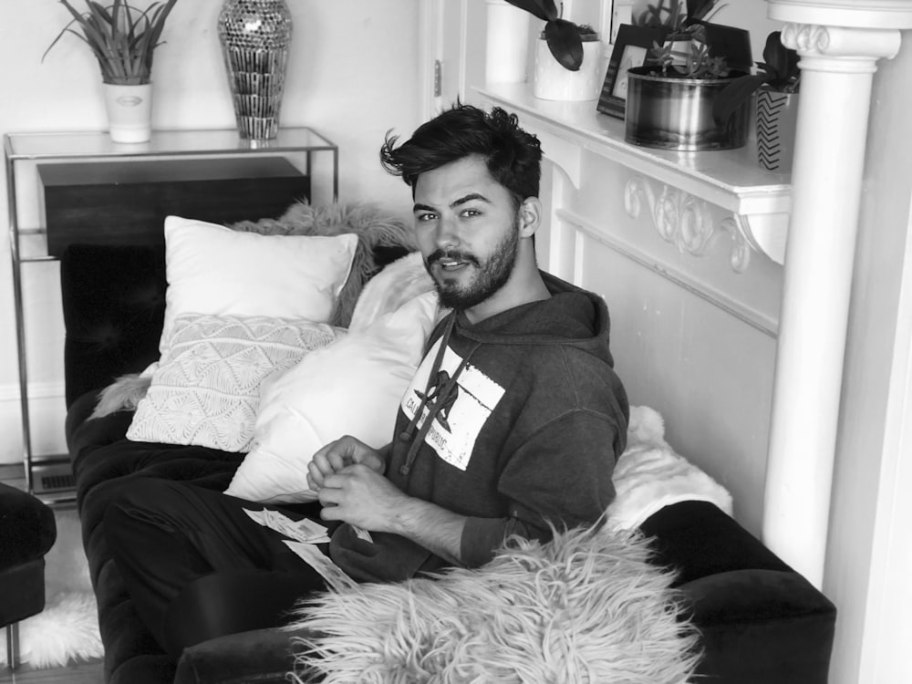 man in black suit sitting on bed