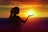 silhouette of woman raising her right hand during sunset
