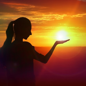 silhouette of woman raising her right hand during sunset