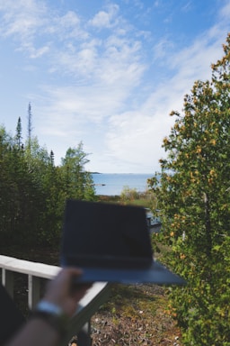 A serene workspace with a laptop overlooking a scenic landscape.