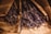 Bundles of dried lavender wrapped in brown paper, resting on a wooden surface. The rich purple hues of the lavender contrast with the earthy tones of the paper and wood.