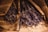 Bundles of dried lavender wrapped in brown paper, resting on a wooden surface. The rich purple hues of the lavender contrast with the earthy tones of the paper and wood.