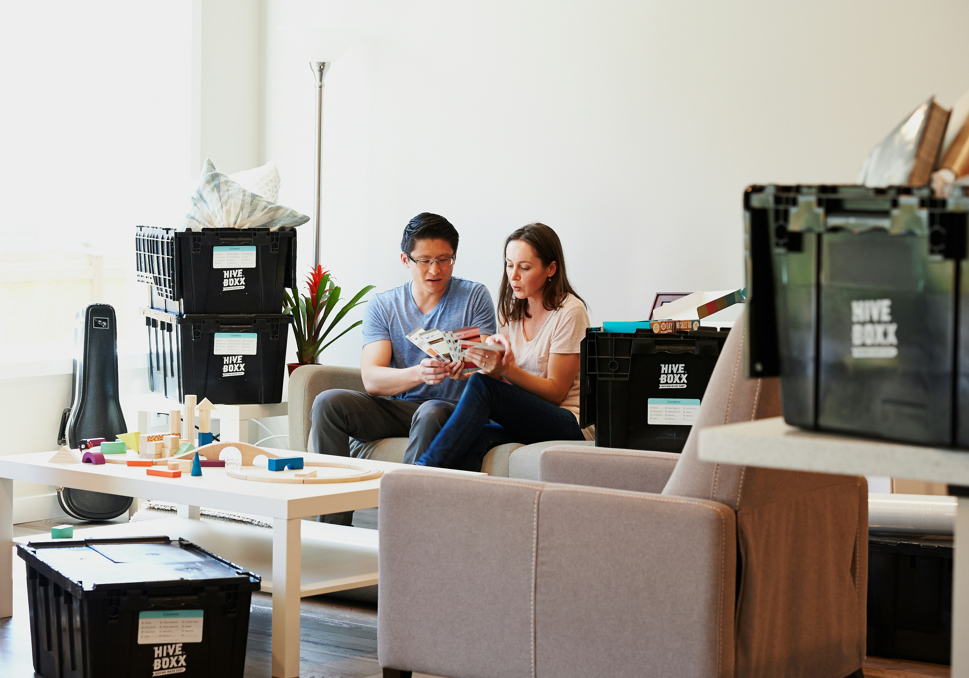 woman in blue long sleeve shirt sitting on brown sofa chair
