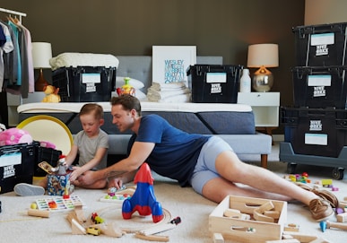 man in blue tank top and gray shorts lying on gray bed
