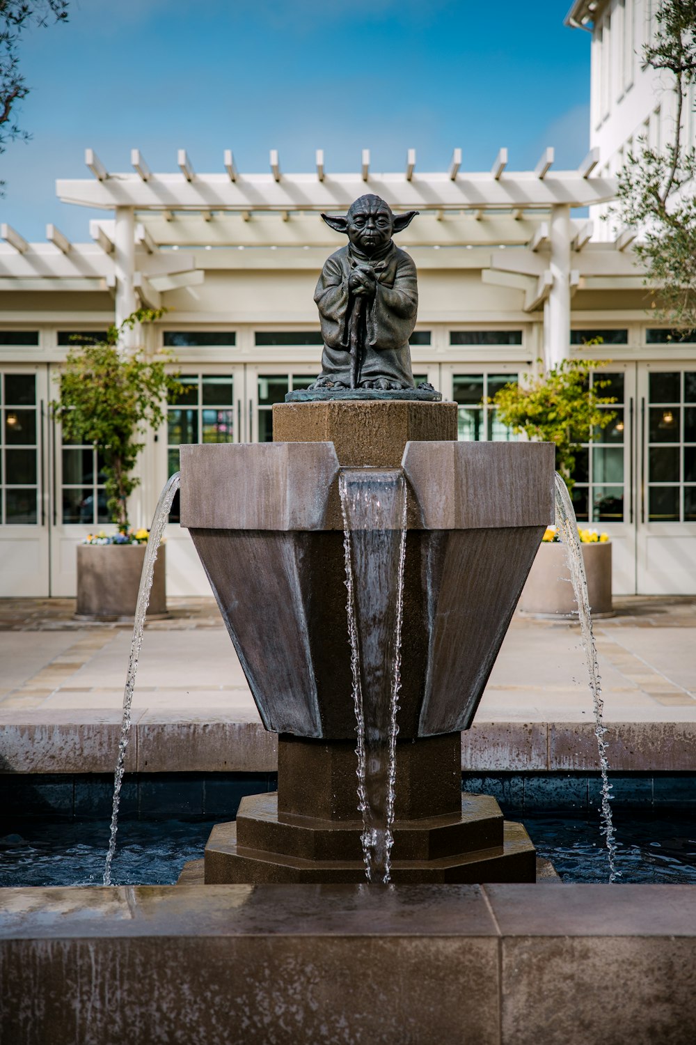 grey concrete fountain near green trees during daytime